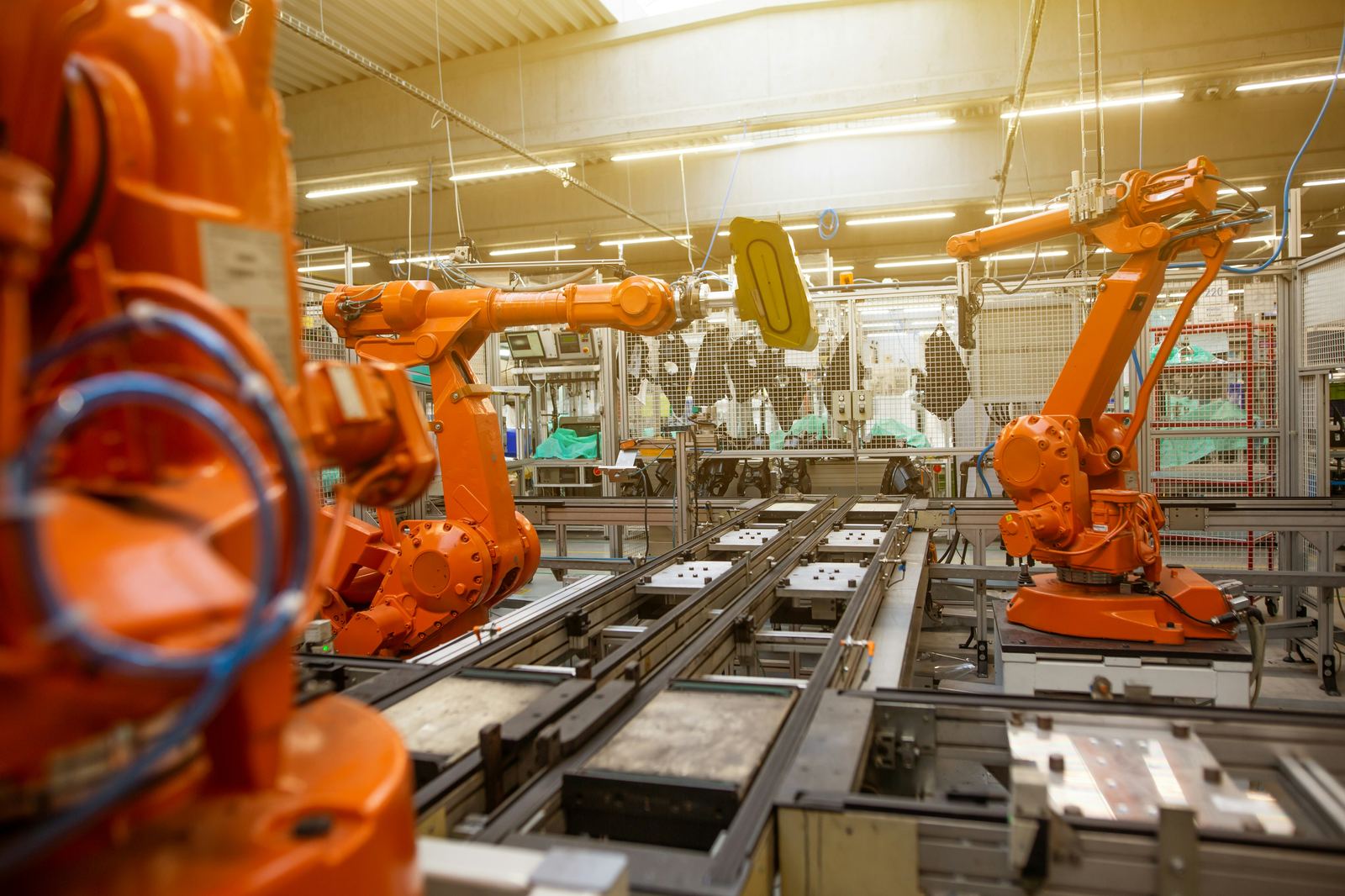 Industrial robotic arms on a manufacturing floor.